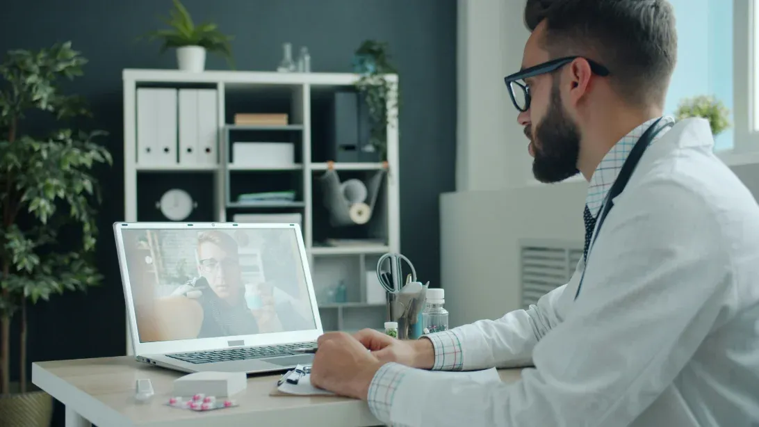 Médica atendendo por videoconferência